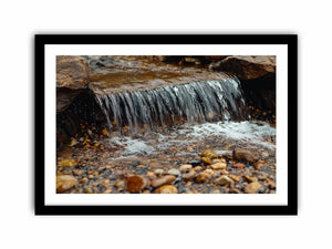 Small creek waterfall photography canvas with rocks and pebbles for peaceful bathroom wall decor.