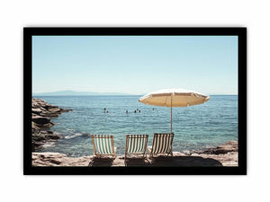 Beach chairs and umbrella overlooking calm sea for coastal decor