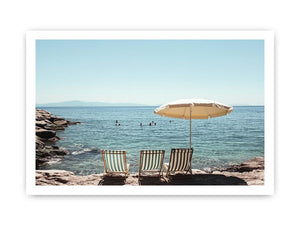 Beach chairs and umbrella overlooking calm sea for coastal decor