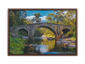 Stone River Crossing a rustic stone bridge spanning a calm river in sunlit woodland