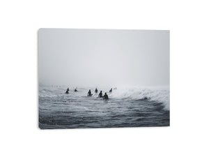 Moody surf canvas art with surfers and misty ocean waves for modern office decor.