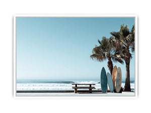 Surfboards and palm trees beside the ocean in coastal modern beach house decor