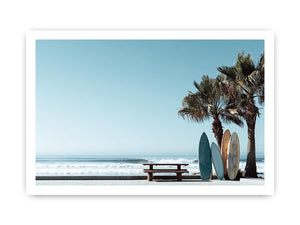 Surfboards and palm trees beside the ocean in coastal modern beach house decor