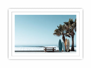 Surfboards and palm trees beside the ocean in coastal modern beach house decor