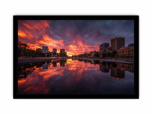 Dramatic city skyline canvas art with fiery sunset reflections for modern decor.