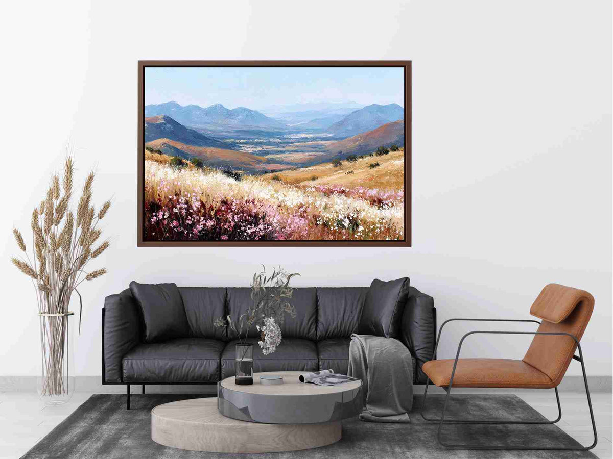 Impressionist mountain valley painting with golden grasslands, pink and white wildflowers, and distant blue peaks for living room decor.