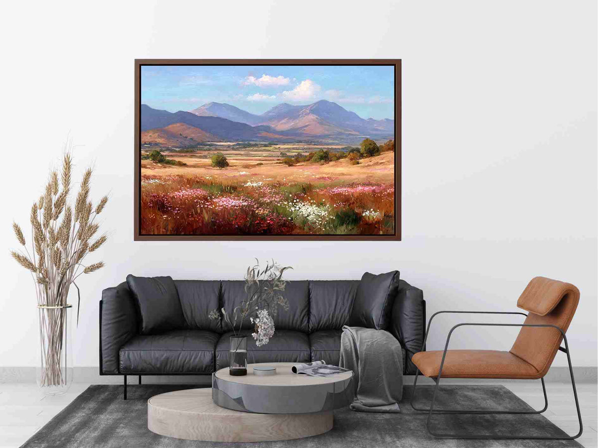 Impressionist mountain valley painting with golden meadows, pink and white wildflowers, scattered trees and blue peaks.