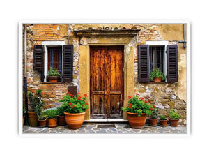 Bright rustic Mediterranean house facade wall art with vintage wooden doors, textured stone walls, and terracotta flower pots in airy natural daylight.