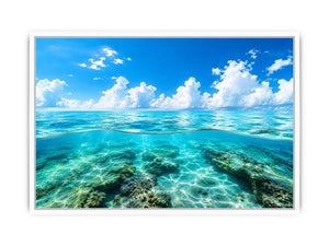 Bright split-view ocean wall art featuring crystal-clear turquoise water, underwater rock formations, and soft clouds beneath a vivid blue sky.