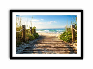 Wooden beach boardwalk leading through coastal dunes toward the ocean shoreline