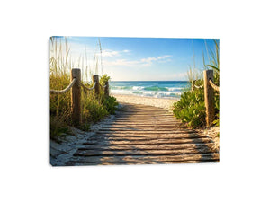 Wooden beach boardwalk leading through coastal dunes toward the ocean shoreline