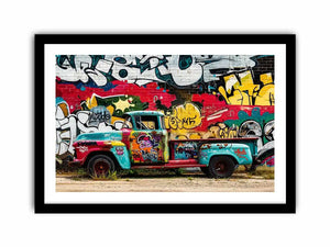 Vintage graffiti pickup truck wall art with colorful urban street mural background.