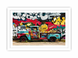 Vintage graffiti pickup truck wall art with colorful urban street mural background.