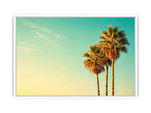 Tall tropical palm trees against soft pastel sky