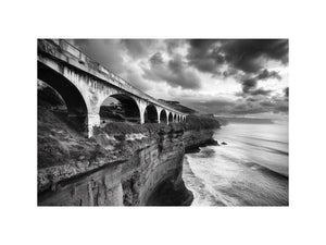 Black and white coastal bridge photography for moody modern office wall decor.