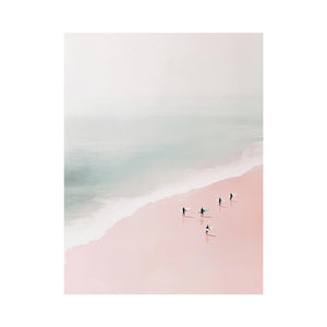 Minimalist coastal photography of surfers on a blush pink beach for modern bedroom decor.
