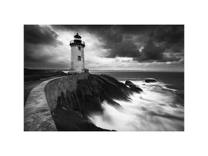 Moody black and white lighthouse wall art with storm clouds for modern living room decor.