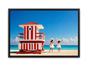 Minimal coastal beach scene with red lifeguard hut blue ocean and two women walking aesthetic wall art