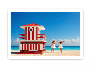 Minimal coastal beach scene with red lifeguard hut blue ocean and two women walking aesthetic wall art