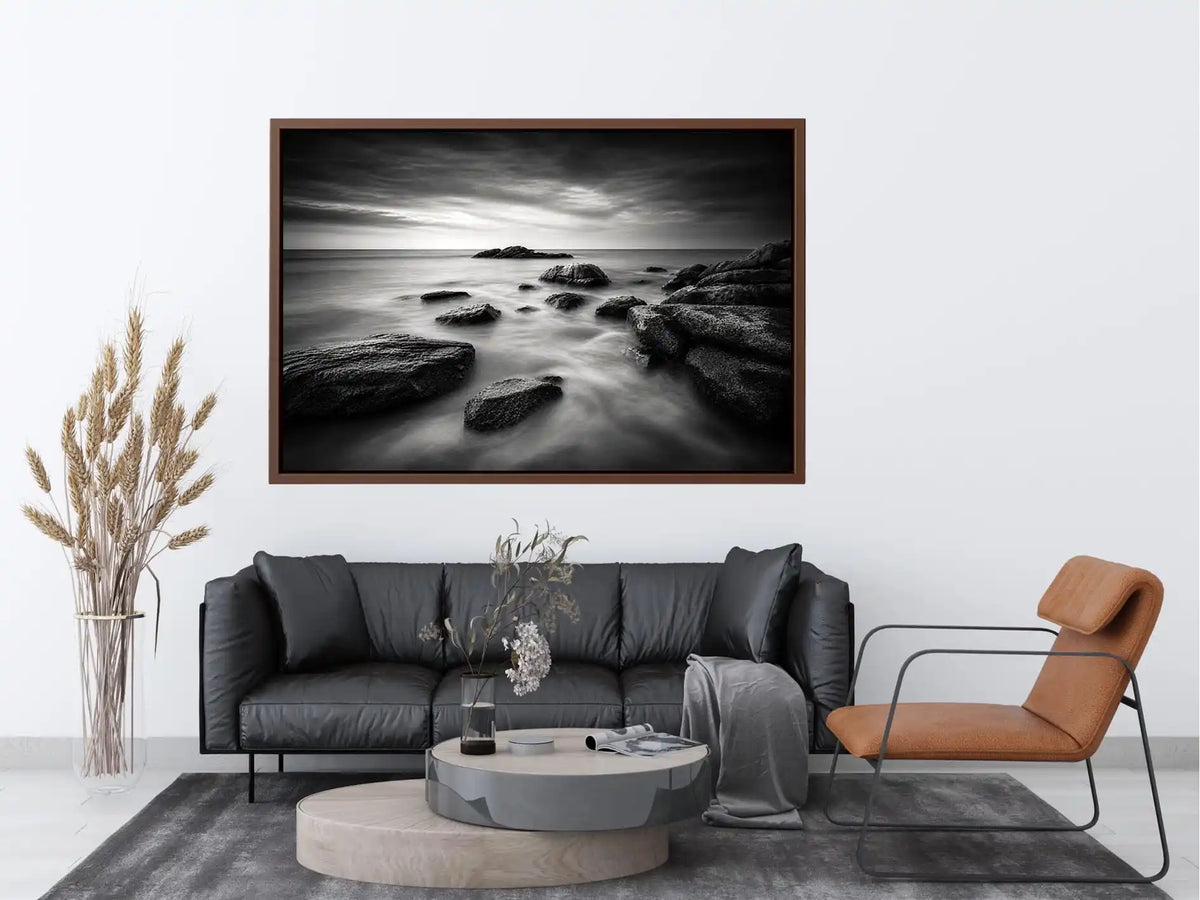 Black and white ocean wall art with dramatic coastal rocks, misty waves, and moody storm clouds in contemporary monochrome seascape style