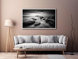Black and white ocean wall art with dramatic coastal rocks, misty waves, and moody storm clouds in contemporary monochrome seascape style