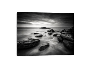 Black and white ocean wall art with dramatic coastal rocks, misty waves, and moody storm clouds in contemporary monochrome seascape style