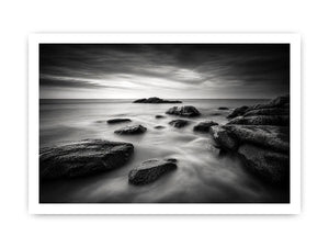 Black and white ocean wall art with dramatic coastal rocks, misty waves, and moody storm clouds in contemporary monochrome seascape style