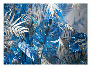 Blue tropical leaf canvas art with silver palm foliage for glamorous modern wall decor.