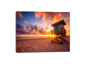 Beach sunset lifeguard wall art with warm sky for coastal bedroom decor.