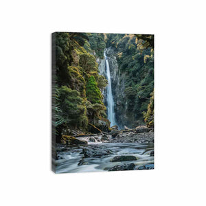 Lush forest waterfall canvas print with rocks and stream for serene living room decor.