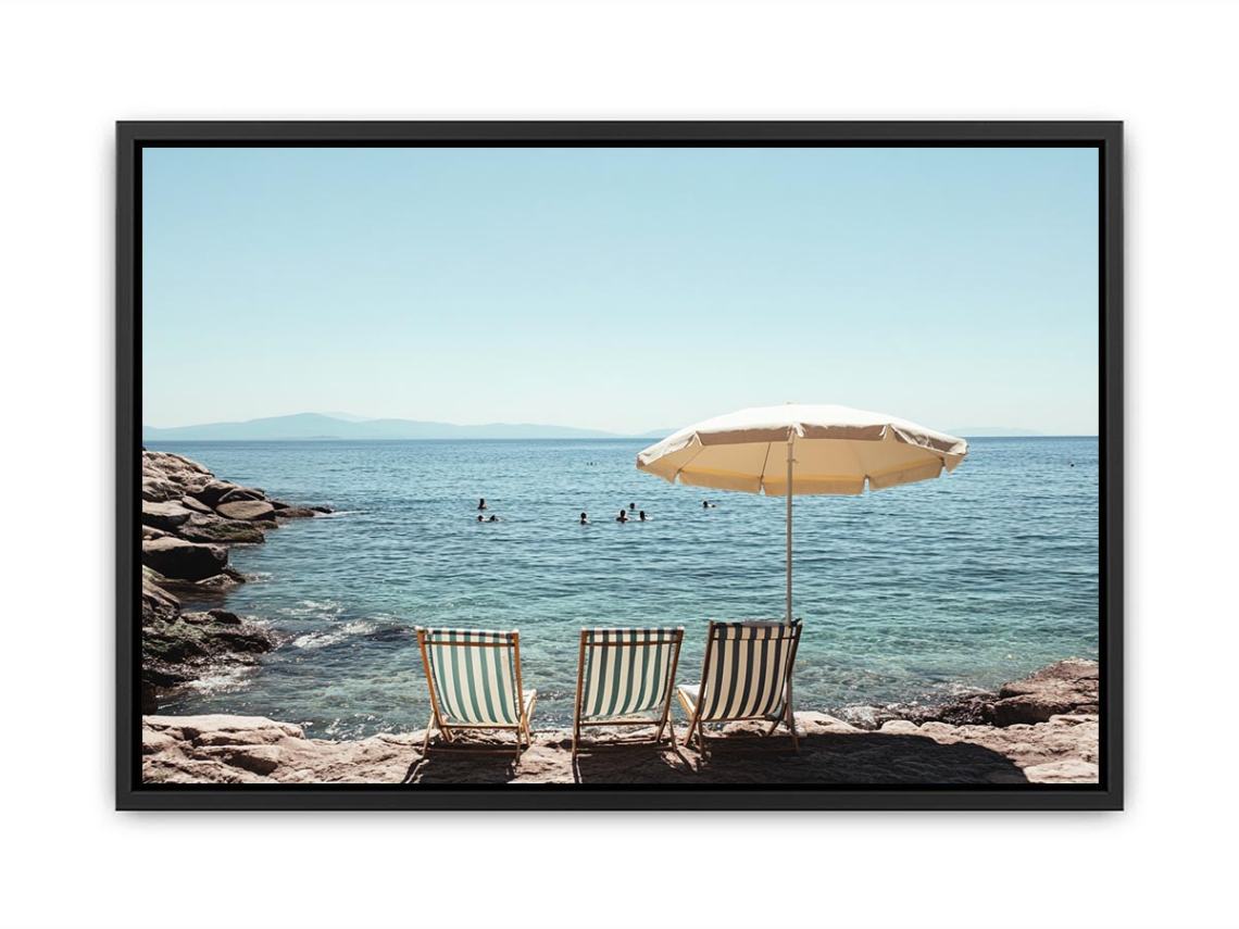 Beach chairs and umbrella overlooking calm sea for coastal decor