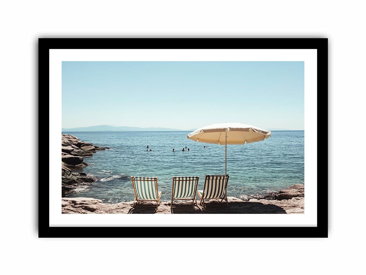 Beach chairs and umbrella overlooking calm sea for coastal decor