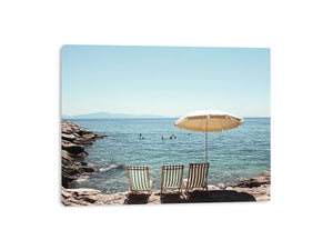 Beach chairs and umbrella overlooking calm sea for coastal decor