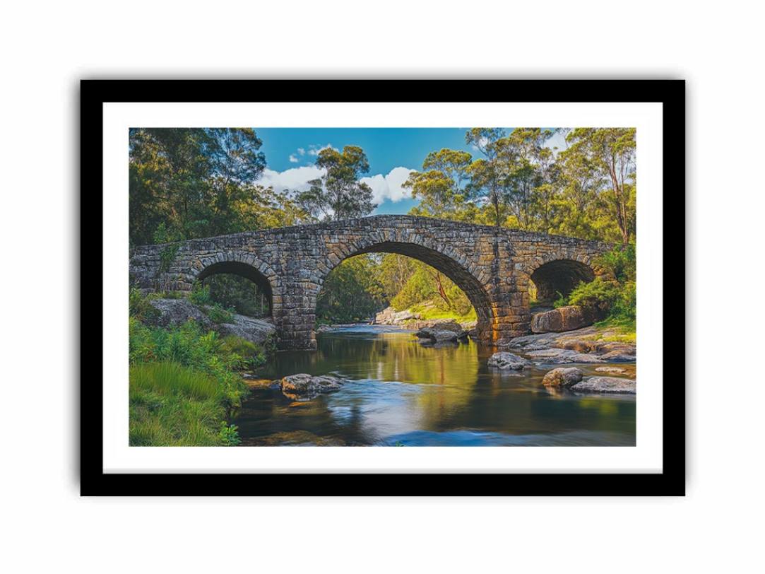 Stone River Crossing a rustic stone bridge spanning a calm river in sunlit woodland