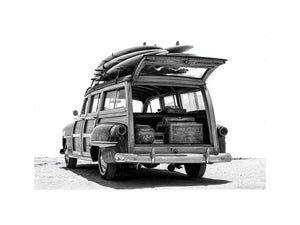 Black and white rear view of vintage woody wagon with surfboards for coastal decor.