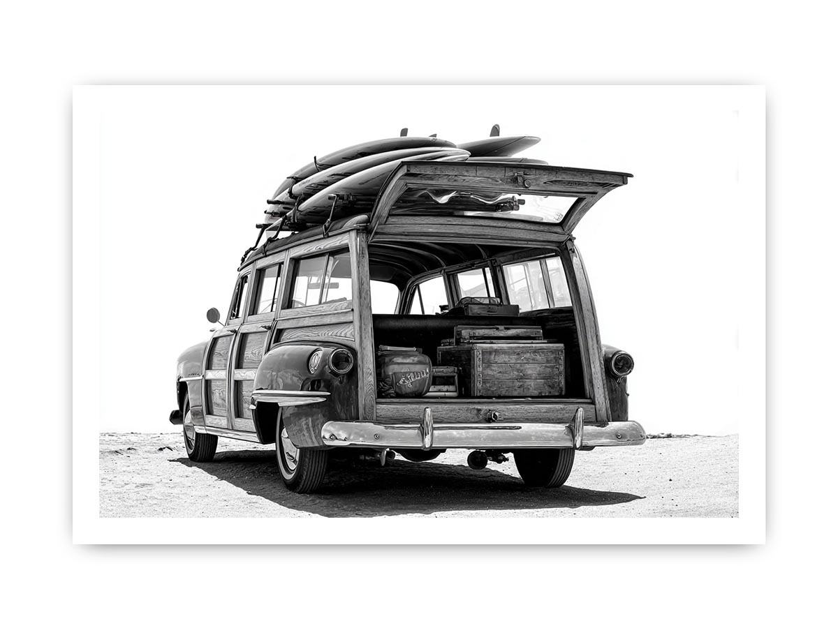 Black and white rear view of vintage woody wagon with surfboards for coastal decor.