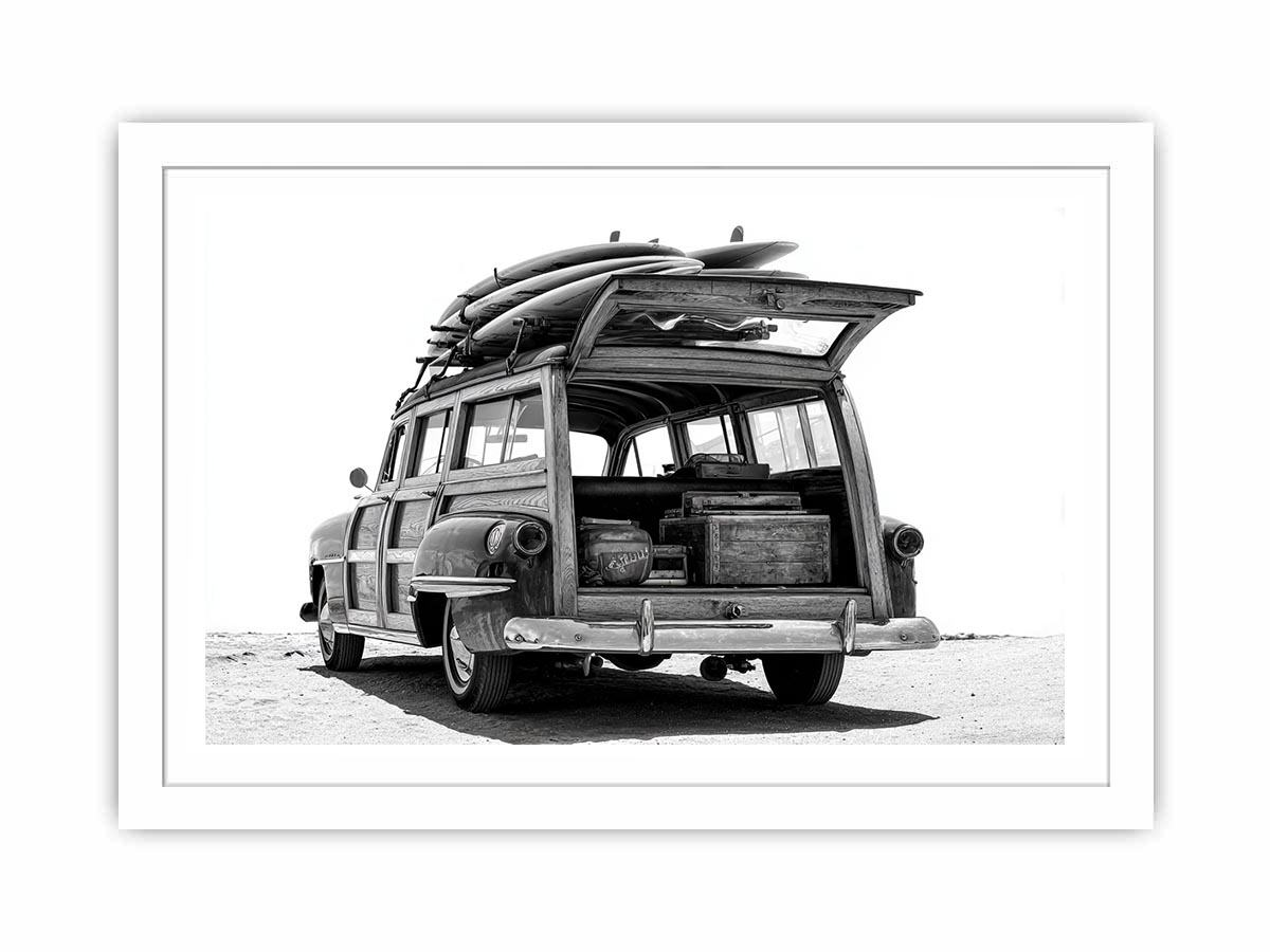 Black and white rear view of vintage woody wagon with surfboards for coastal decor.