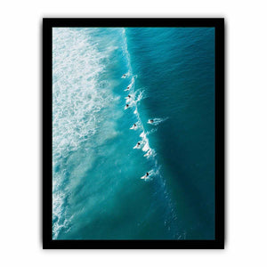 Aerial coastal photography of surfers on turquoise ocean waves for modern beach house decor.