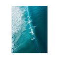 Aerial coastal photography of surfers on turquoise ocean waves for modern beach house decor.