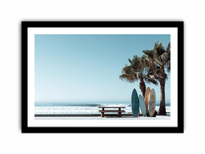 Surfboards and palm trees beside the ocean in coastal modern beach house decor