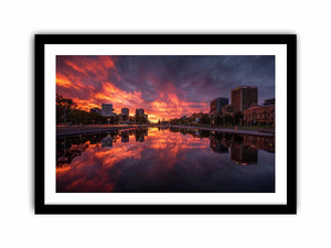 Dramatic city skyline canvas art with fiery sunset reflections for modern decor.
