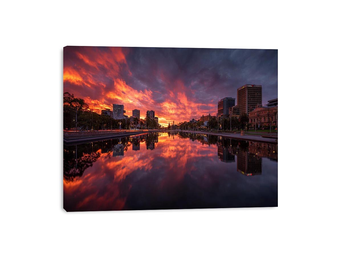 Dramatic city skyline canvas art with fiery sunset reflections for modern decor.