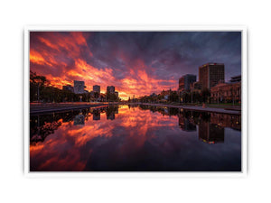 Dramatic city skyline canvas art with fiery sunset reflections for modern decor.