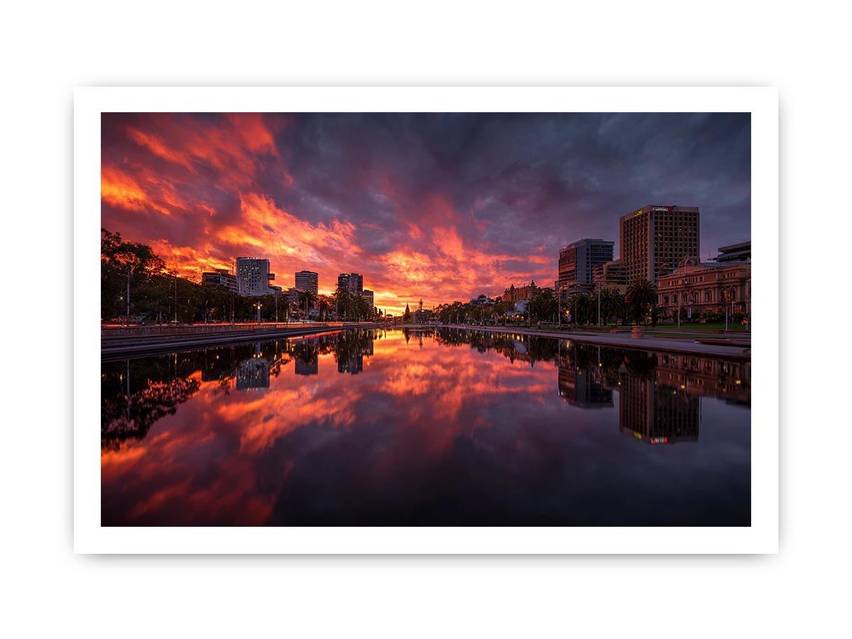 Dramatic city skyline canvas art with fiery sunset reflections for modern decor.