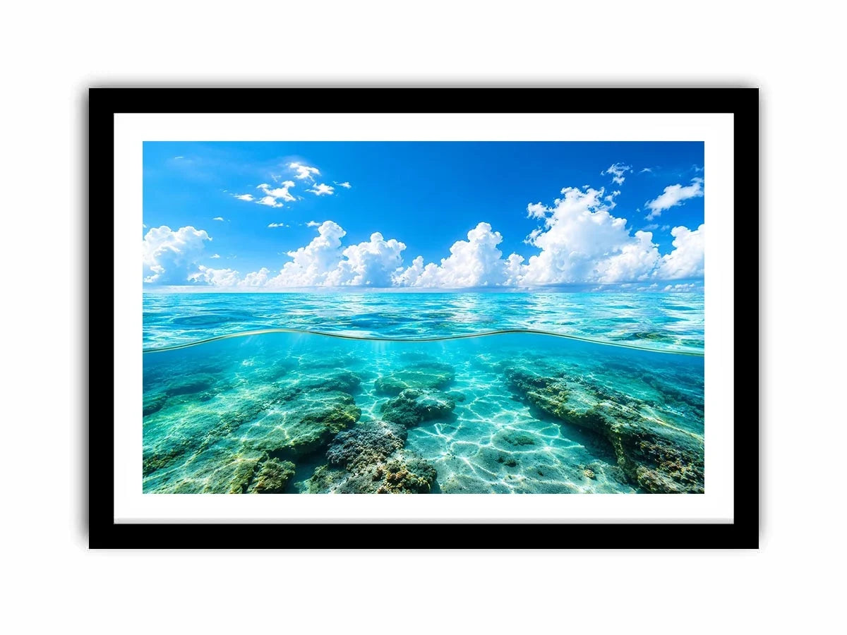 Bright split-view ocean wall art featuring crystal-clear turquoise water, underwater rock formations, and soft clouds beneath a vivid blue sky.