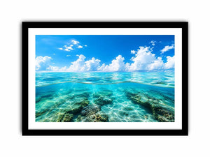 Bright split-view ocean wall art featuring crystal-clear turquoise water, underwater rock formations, and soft clouds beneath a vivid blue sky.