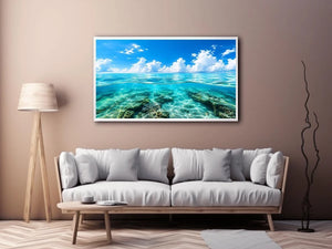 Bright split-view ocean wall art featuring crystal-clear turquoise water, underwater rock formations, and soft clouds beneath a vivid blue sky.