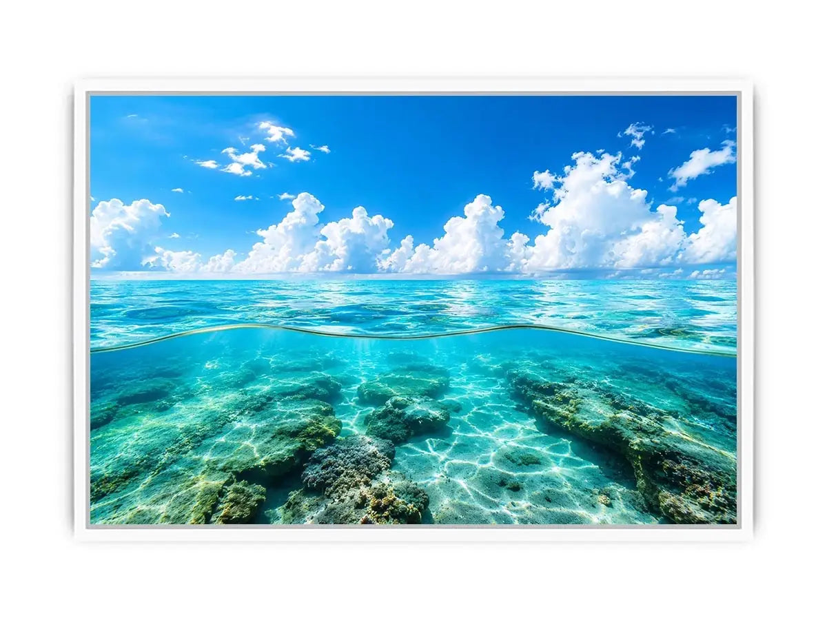 Bright split-view ocean wall art featuring crystal-clear turquoise water, underwater rock formations, and soft clouds beneath a vivid blue sky.