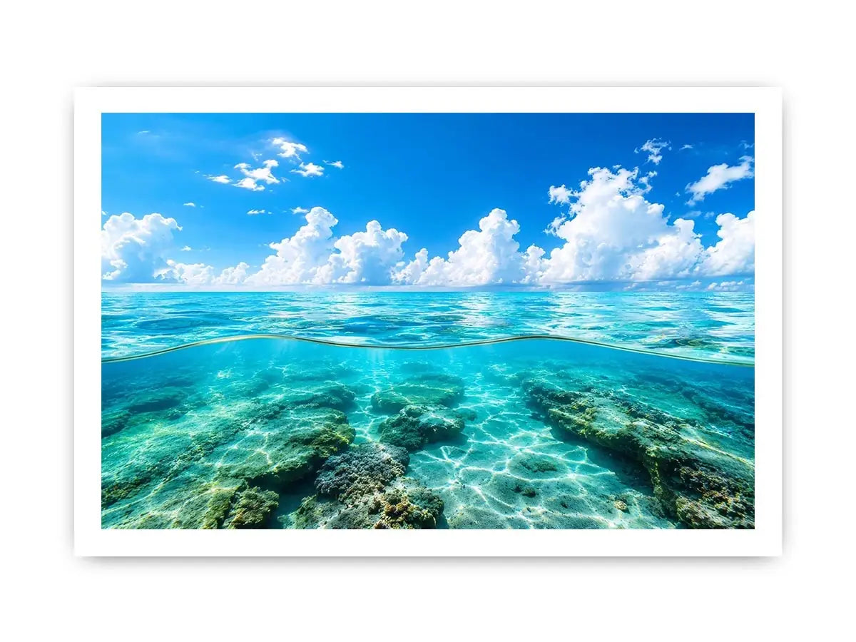Bright split-view ocean wall art featuring crystal-clear turquoise water, underwater rock formations, and soft clouds beneath a vivid blue sky.