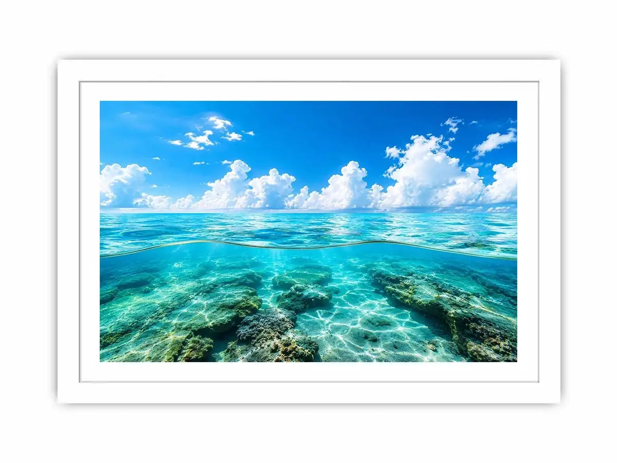 Bright split-view ocean wall art featuring crystal-clear turquoise water, underwater rock formations, and soft clouds beneath a vivid blue sky.